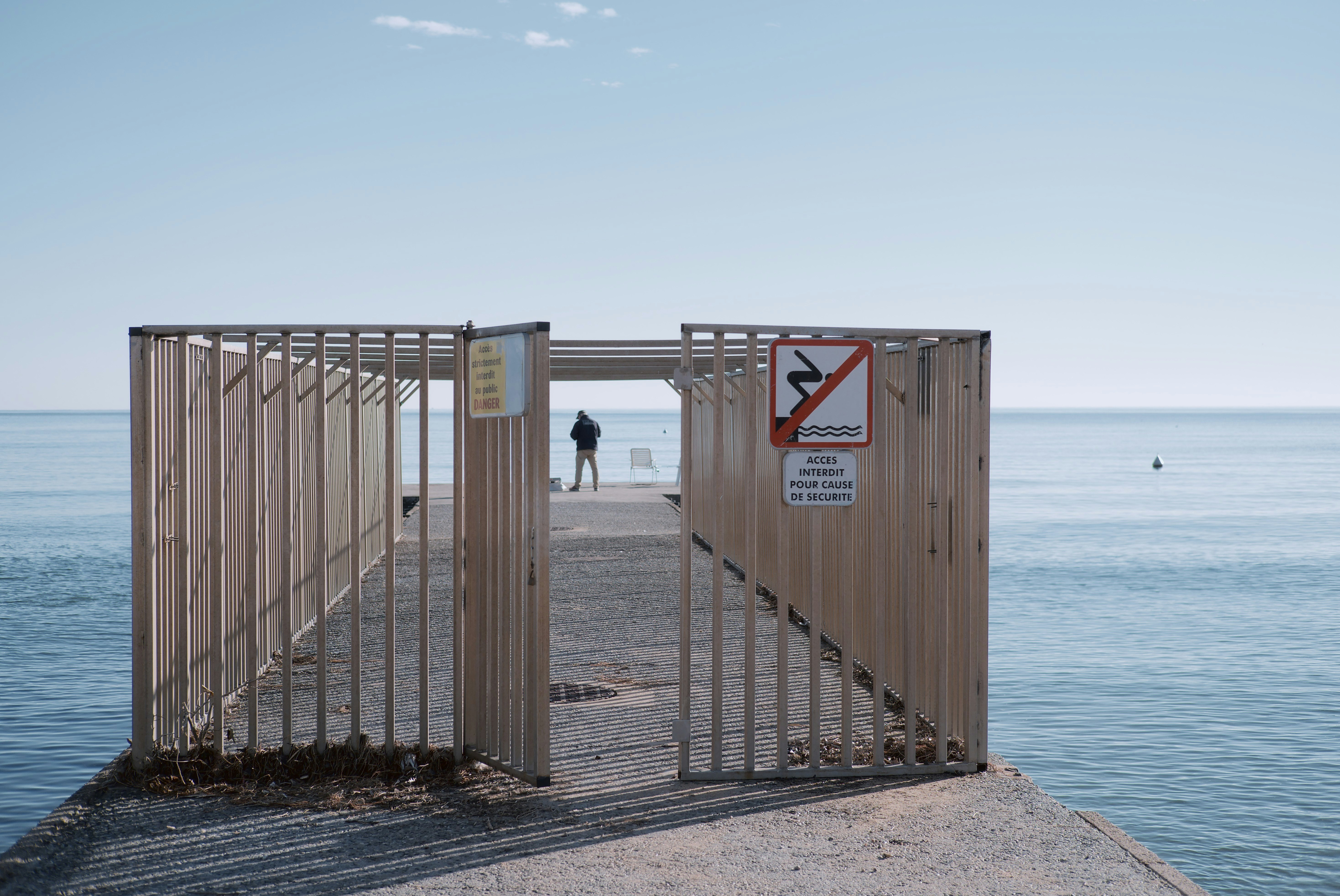 brown wooden fence near body of water during daytime